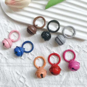 Detailed view of colorful metal bell pendants with spring snap hooks for DIY keychain decor.