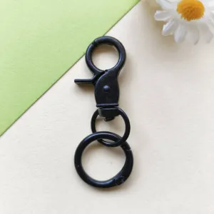Dettaglio moschettone girevole in metallo nero, anello a molla portachiavi accessorio borsa DIY primo piano