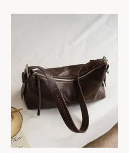 Dark brown leather hobo shoulder bag detail, vintage pillow style with secure zipper closure.