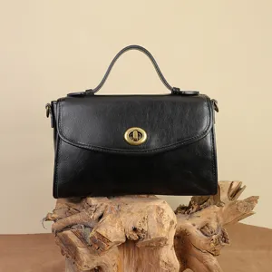 Black genuine leather messenger bag with top handle and vintage turn-lock closure for women.