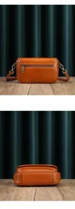 Detailed view of the brown leather crossbody bag showing the back zipper and bottom structure.