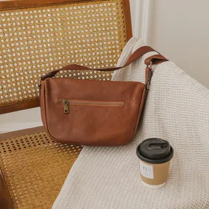 Genuine leather shoulder bag for women, stylish brown crossbody dumpling bag with zip.