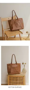 Detail view of brown leather tote bag showcasing soft texture and large capacity style.