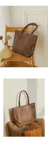 Detailed view of the brown leather tote bag, showing soft texture and spacious interior design.