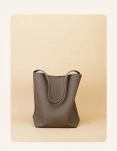 Detailed view of taupe leather tote bag, showing premium texture, smooth lines and spacious design.