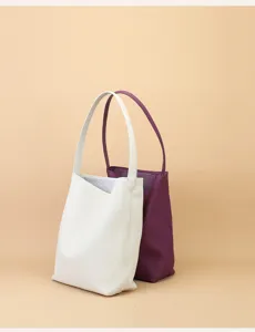 Detailed view of minimalist leather tote bags in white and purple, premium commuter style.