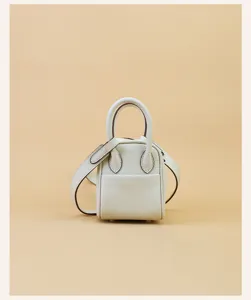 Mini leather shoulder bag detail showcasing premium white cowhide texture and refined metal hardware.