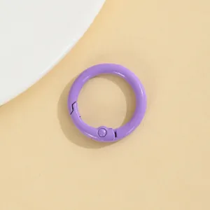 Gedetailleerde close-up van een paarse metalen veerring, ideaal voor DIY-sieraden en sleutelhangers.