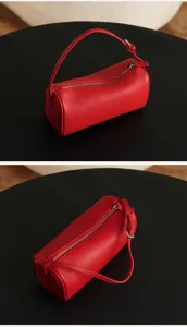Red leather cylindrical shoulder bag, minimalist chic pillow bag with stylish silver zipper.