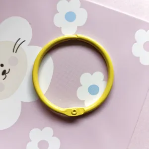 Vue détaillée d'un anneau de reliure en métal jaune 45mm, idéal pour les loisirs créatifs DIY.