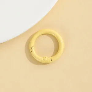 Close-up van een kleine gele ronde veerring, detailopname van metalen doe-het-zelf accessoire.