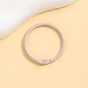 Close-up view of a light pink baked paint metal loose leaf ring book binder accessory detail shot.