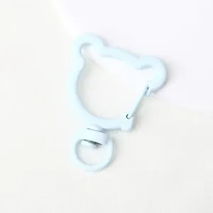 Close-up of a light blue bear-shaped keychain ring, smooth painted finish, swivel base detail.