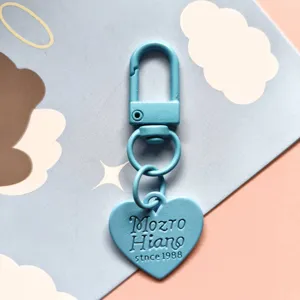 Close-up of a cute blue metal heart keychain with enamel baking paint finish and cute pendant.