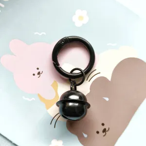 Black metal spring ring keychain with cute bell pendant, minimalist bag charm accessory.