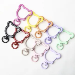 Detailed view of colorful bear-shaped metal spring rings, swivel clasps for DIY jewelry and keychains.