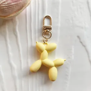 Cute yellow balloon dog keychain bag charm accessory detail shot for stylish bags and keys