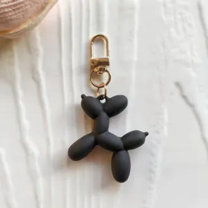 Black balloon dog keychain pendant with gold metal clasp, cute bag charm ornament gift style.