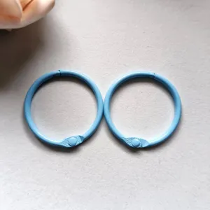 Close-up detail shot of light blue metal loose leaf binder rings for DIY crafts and keys.