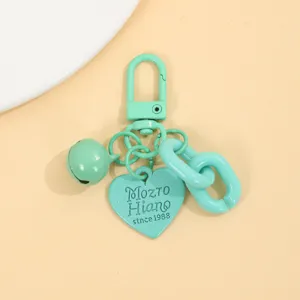 Détail de porte-cle vert menthe mignon avec pendentif coeur et cloche pour sacs et accessoires.