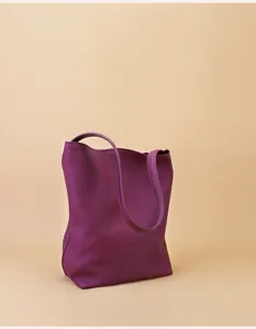 Detailed view of the deep purple genuine leather tote bag, showing soft texture and straps.