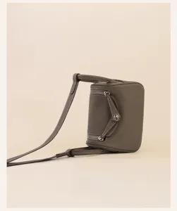 Detailed view of the stylish mini leather shoulder bag with gold tone hardware and dual straps.