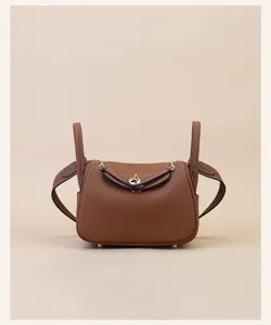 Mini leather crossbody shoulder bag with top handles and gold-tone hardware closure.