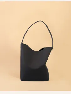Minimalist black leather shoulder bag for women, stylish underarm commuting bucket bag.