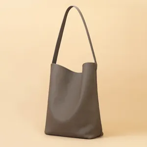 Minimalist taupe leather bucket shoulder bag for women, large capacity daily commuter tote bag.