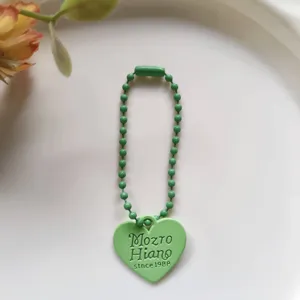 Minimalist green heart ball chain keychain detail, cute DIY phone charm and bag accessory.