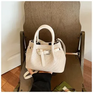 Detailansicht der schicken beige gewebten Beuteltasche mit stilvollem Gürtelschnallen-Design.