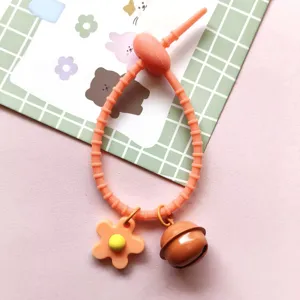 Silicone cable tie strap with cute flower and bell charm for DIY bag pendant detail.