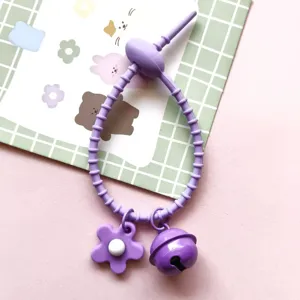 Purple silicone tie accessory with cute flower charm and bell detail for DIY bags and items.