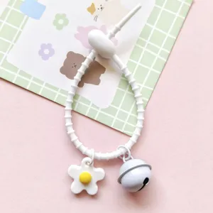 Detailed view of white silicone strap keychain featuring a cute daisy flower and bell.