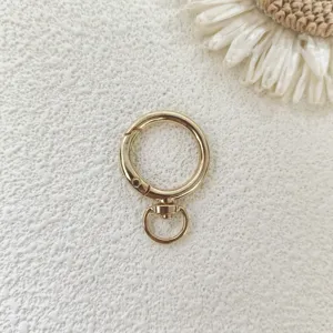Close up of gold round rotating spring ring metal hardware detail for bags and DIY crafts.