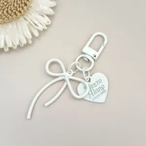 Weißer Legierung Schleife Schlüsselanhänger mit Herz Etikett, süßes DIY Schmuckzubehör für Handys.