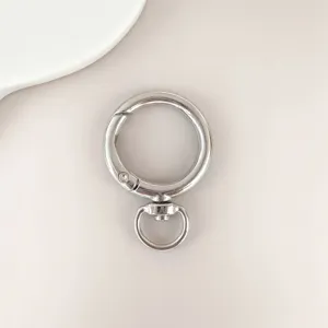 Silver zinc alloy rotatable round spring buckle, bag hardware accessory detail close-up view.