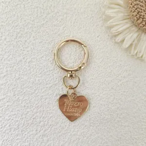 Gold metal keychain hardware detail, heart pendant with engraved text, sturdy swivel spring snap hook.