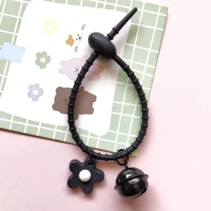 Black silicone cable tie accessory with flower pendant and bell for DIY bag keychains.