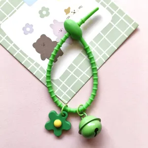 Green silicone cable tie strap with cute flower and bell pendants for DIY bag phone charms.