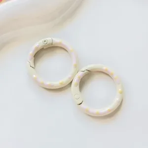 Close-up detail of metal donut spring rings, colorful oil drop cute DIY jewelry accessories.