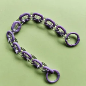 Dettaglio ravvicinato del cinturino a catena in acrilico con maglie viola per borse.