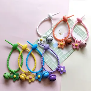 Candy color silicone cable tie keychain charm with flower and bell detail view for bags.