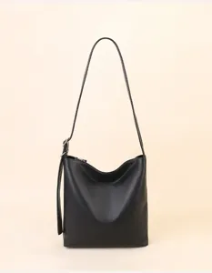 Detailed view of black leather shoulder bag, minimalist slouchy design for everyday commute.
