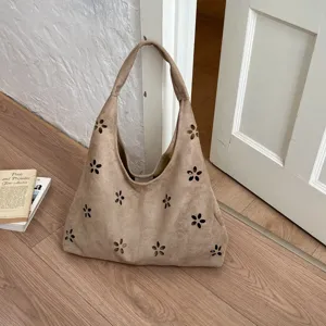 Vista dettagliata della borsa a spalla in camoscio cachi con motivo floreale intagliato.