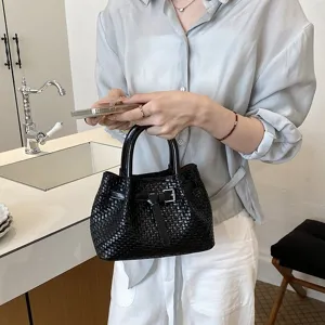 Schicke schwarze geflochtene Damentasche als Eimerbag mit edler Schnalle und zwei Tragegriffen.