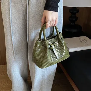 Detailansicht der stilvollen grünen Leder Handtasche im eleganten Flechtmuster Design.