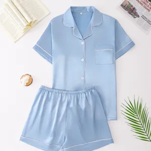 Light blue silk pajama set detail, short sleeve top and shorts with white piping, loungewear.