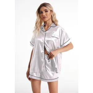 Detailed view of women's silky satin short sleeve pajama set with chic black piping design.