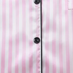 Close-up detail of pink and white striped satin pajamas with black piping and buttons.